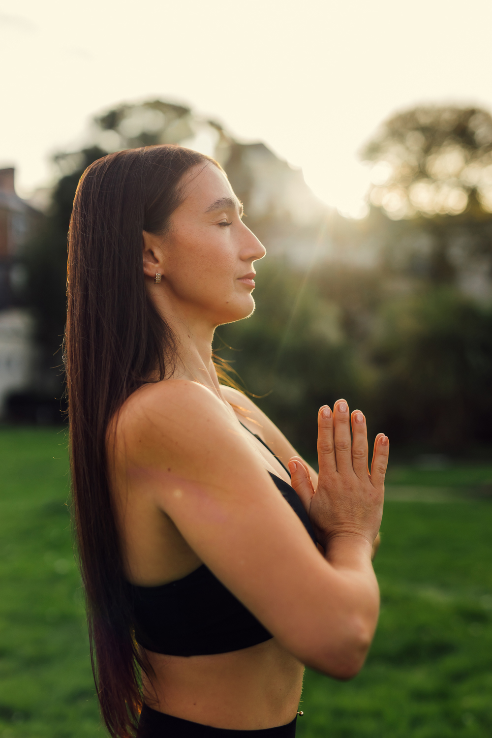 Yoga portrait at sunset with hands in prayer