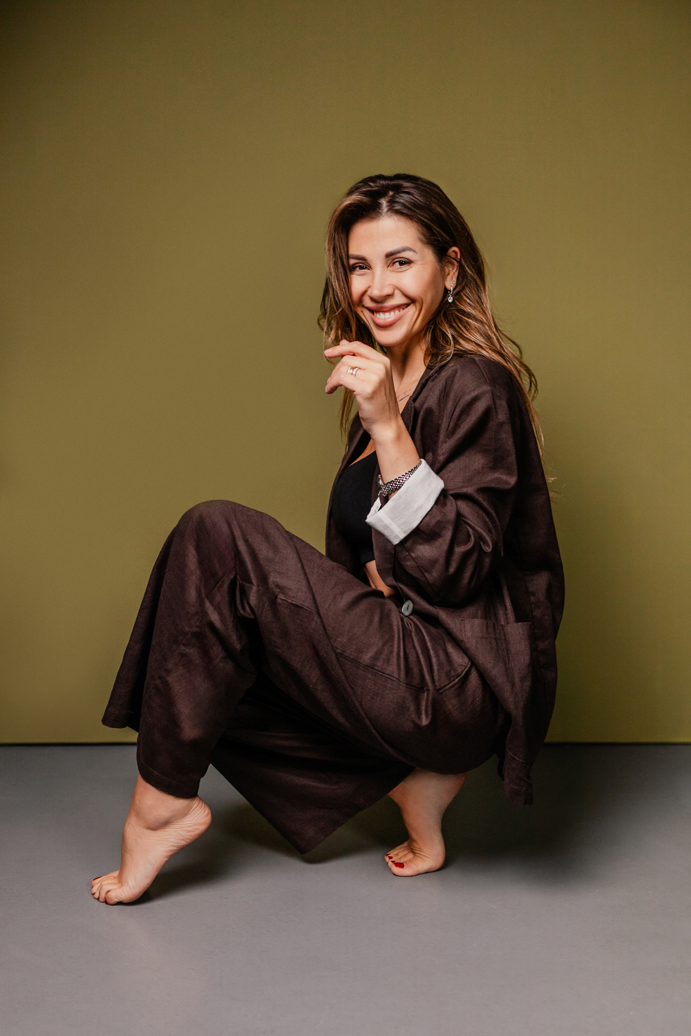 Fashion-led studio portrait against an olive backdrop