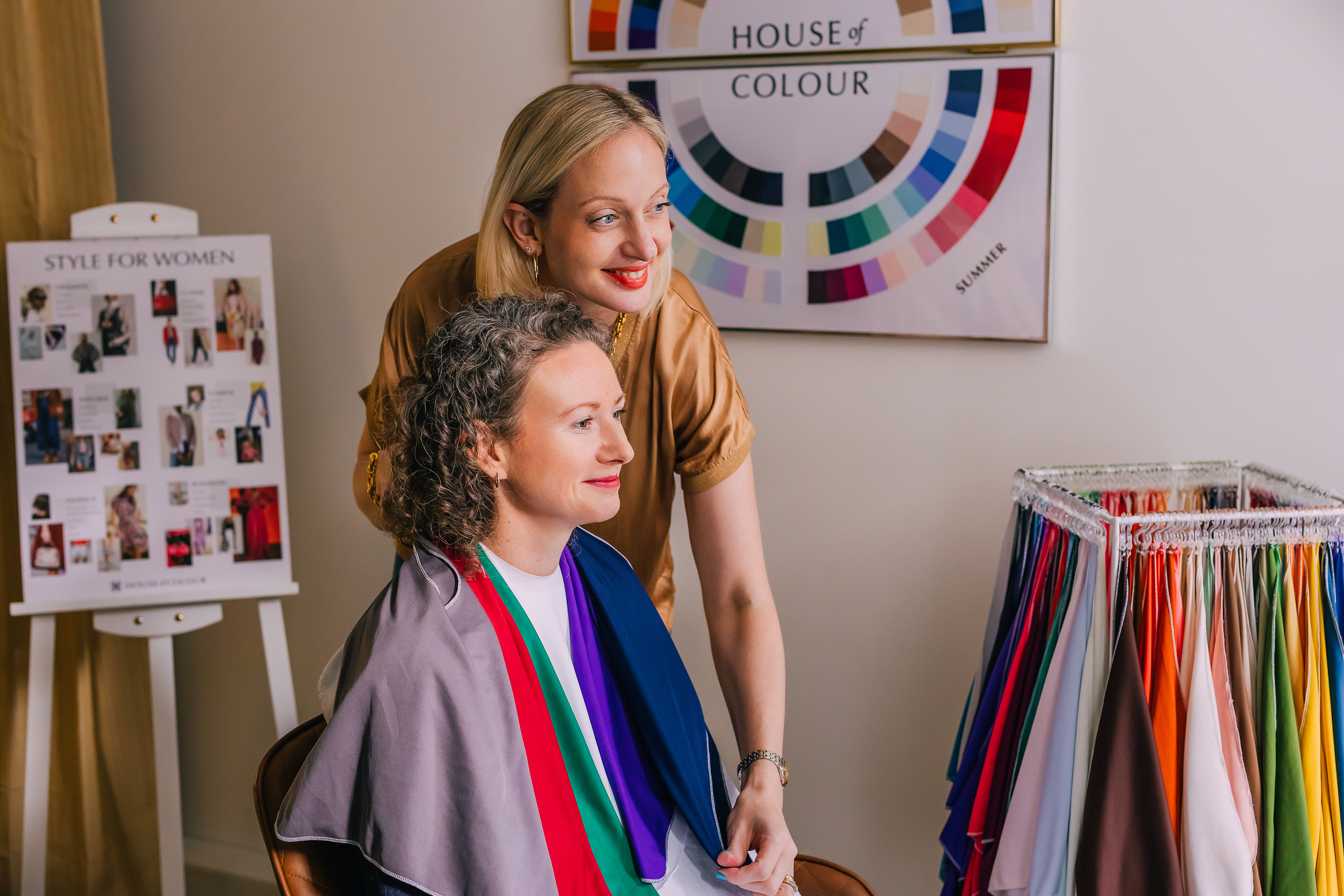 Colour stylist guiding a seated client through drapes
